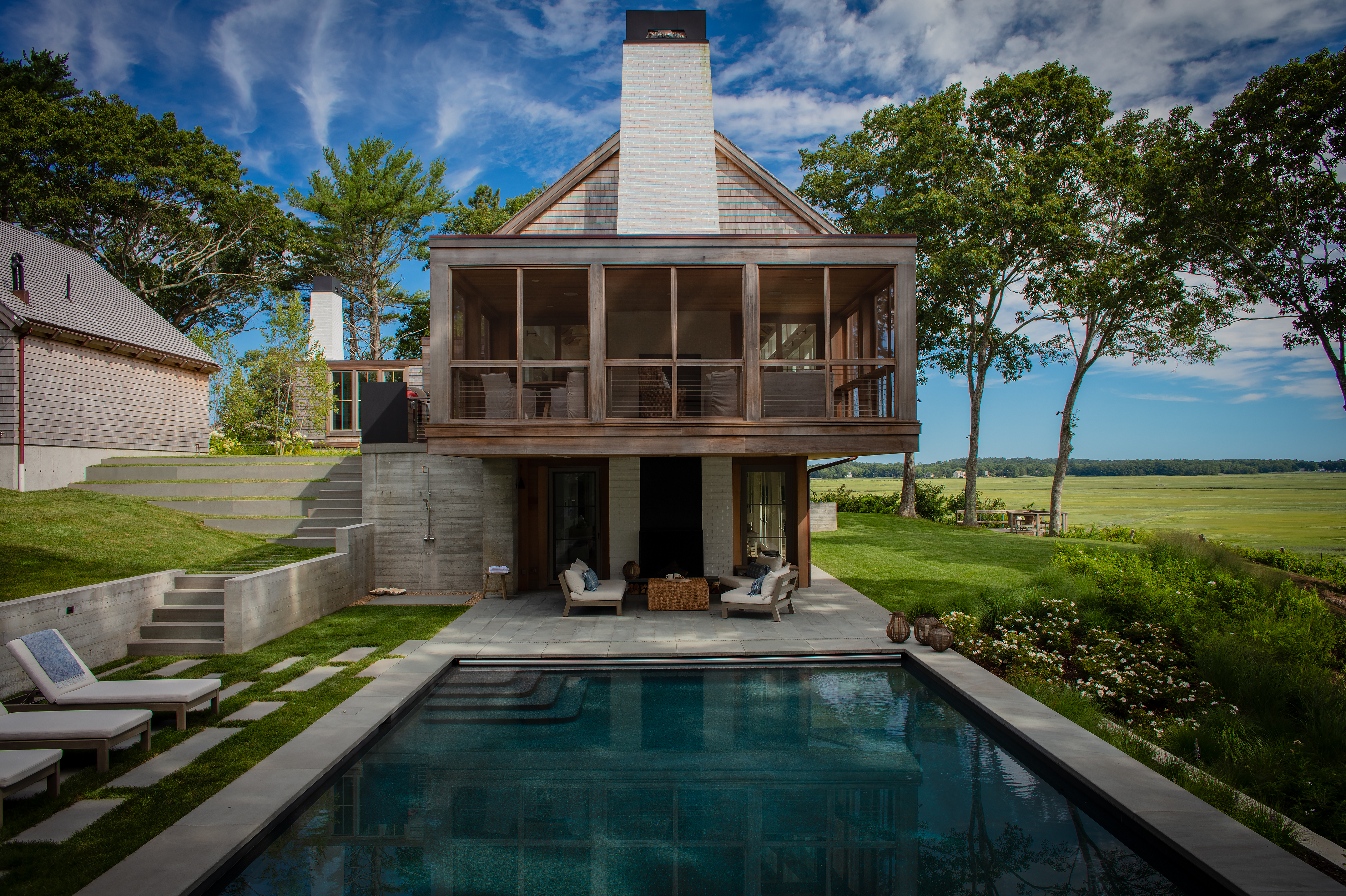 midday view of cantilevered screen porch and pool area with the Duxbury saltmarsh in the background